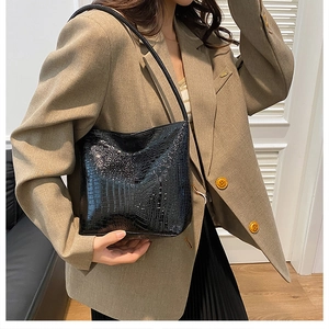 Glossy black crocodile pattern shoulder bag shown with chic beige blazer outfit