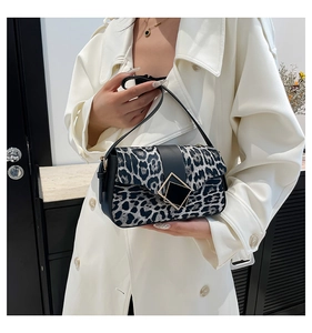 Fashionable leopard print shoulder bag worn with a white trench coat in a stylish setting