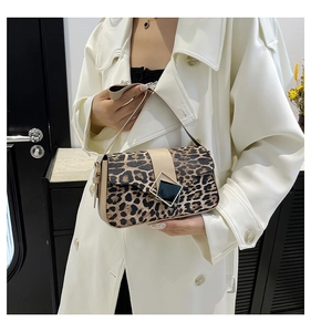 Detail of leopard print underarm bag with square metal buckle on white coat