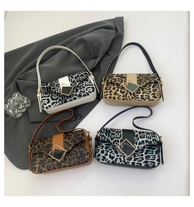 Detailed view of four leopard print shoulder bags with square metal buckles on a blazer