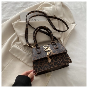 Detail of leopard print handbag with gold metal logo and fringe tassel accessory