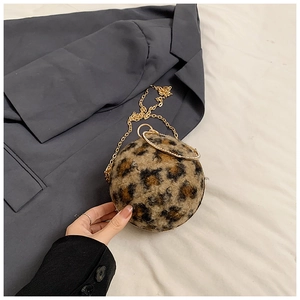Detail of spherical leopard print plush bag featuring a gold chain and diamond ring handle