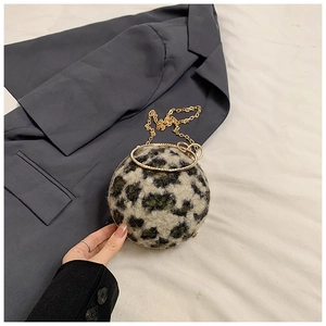 Detail of spherical leopard print faux fur clutch with crystal-encrusted gold ring handle