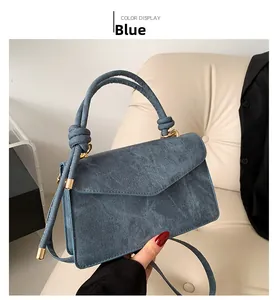 Λεπτομέρεια της μπλε τσάντας denim με λαβή κόμπο και χρυσά μεταλλικά στοιχεία