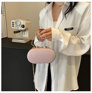 Dettaglio della borsa da sera rosa glitterata con manico dorato e chiusura a fiocco