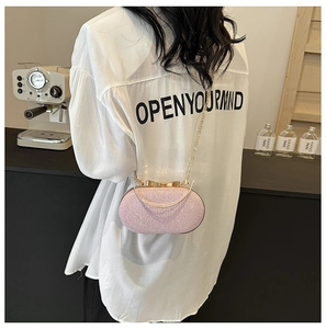 Pochette da sera rosa glitterata con chiusura a fiocco dorata indossata da una modella
