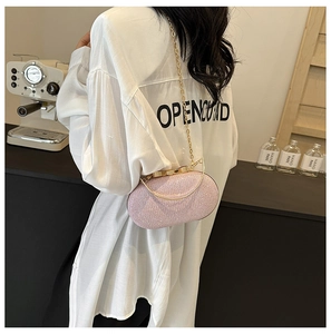 Borsa da sera rosa con paillettes e catena dorata mostrata su modella in scena