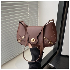 Detail of dark brown leather underarm bag with gold metal twist lock and rivets