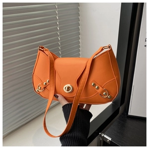 Detail of a vibrant orange crescent bag featuring gold metal turn-lock and PU leather texture