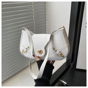 Close-up of white crescent bag showing golden twist-lock and rivet details on leather