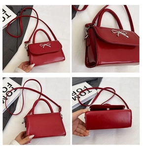 Macro details of a red patent leather handbag featuring a silver metal bow buckle