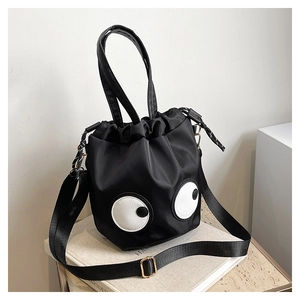 Detail view of nylon drawstring bucket bag with funny eye patches and adjustable strap