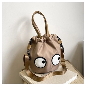 Detail of quirky googly eye nylon bucket bag with drawstring closure and adjustable strap
