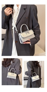 Close-up of a silver bow-knot crossbody bag showcasing the metallic texture and strap