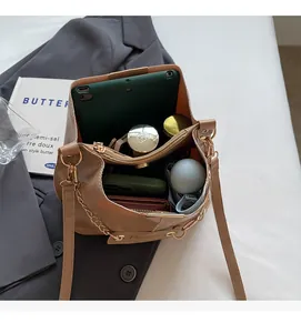 Spacious interior of khaki bucket bag showing tablet, phone, and makeup storage
