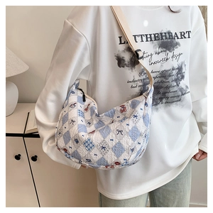 Quilted crossbody bag with blue plaid patterns and cute bear print shown on a model