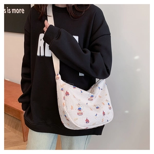 Detailed view of the circus print crescent bag with wide canvas shoulder strap and zipper