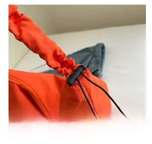 Detail of orange nylon dumpling bag showing elastic drawstring and adjustable plastic buckle