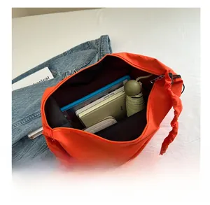 Spacious interior of a pleated drawstring tote bag holding a tablet and daily essentials
