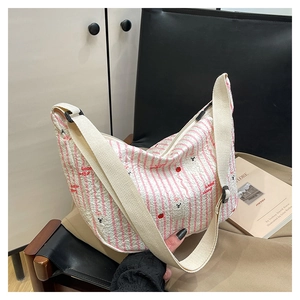 Detail of pleated fabric texture with strawberry and bear print on the crossbody bag