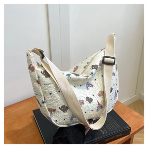 Detail of white pleated fabric shoulder bag featuring cute elephant print and wide strap