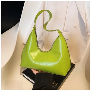 Detail of lime green glossy leather shoulder bag with sleek zipper and logo embossment