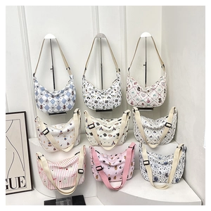 Various canvas crescent bags featuring diverse cartoon prints and adjustable straps