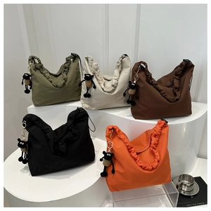 Detail of nylon pleated tote bags in five colors with a plush sheep charm pendant
