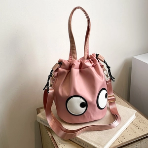 Pink nylon bucket bag with cartoon eyes design and adjustable shoulder strap