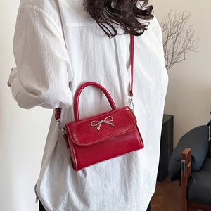 Mini borsa rossa lucida con fiocco argento e tracolla a catena per donna elegante