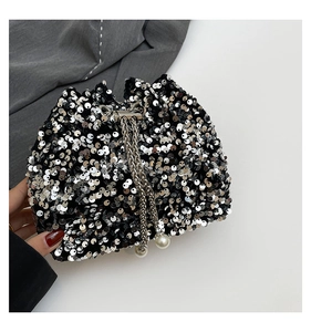 Detail of silver sequin bucket bag featuring metallic chain drawstring and pearl accents