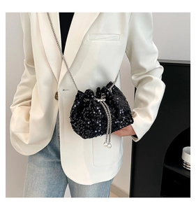 Detail of black sequined bucket bag with pearl drawstring and silver chain strap
