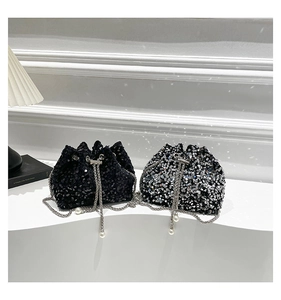 Detailed view of sequined bucket bags with drawstring closures and pearl chain straps
