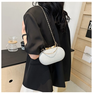 Dettaglio pochette argento glitterata con manico oro indossata da una modella