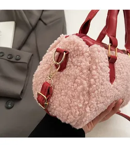 Detail view of pink fleece pillow bag with red leather trim and gold metal hardware