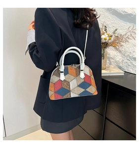 Detail of color-block shell bag with geometric patterns and white leather handle