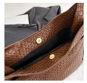 Primer plano de bolso tote tejido marrón mostrando detalle de hebilla metálica magnética