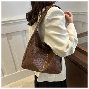 Close-up of brown woven leather texture on a hobo shoulder bag with wide strap