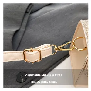 Detail of adjustable cream leather shoulder strap with gold-tone hardware and lobster clasp