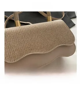Detail of glitter flap and scalloped edge on beige leather crossbody handbag