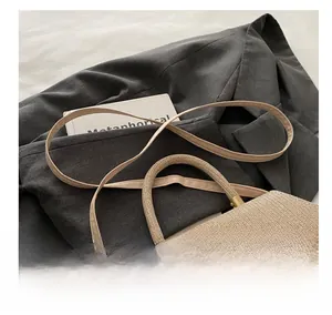 Detail view of woven leather small square bag featuring comfortable shoulder strap handle