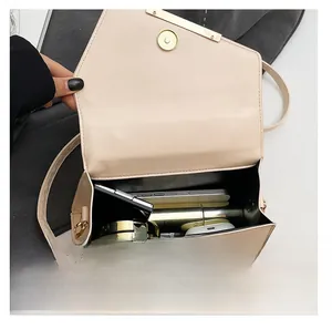 Detail view of the beige leather handbag interior showing storage for phone and cosmetics