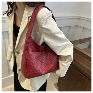 Detail of red woven large capacity shoulder bag with intricate Intrecciato texture