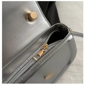 Details des glatten Metallreißverschlusses und der goldenen Hardware der Satteltasche