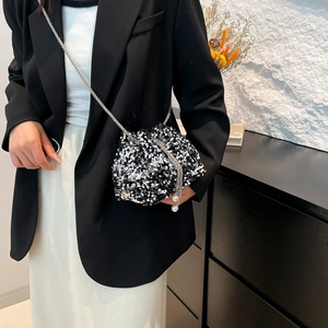 Silver sequin drawstring bucket bag with chain strap and pearl charms on model