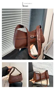Detailed close-up of brown polished PU leather shoulder bag with decorative strap buckle