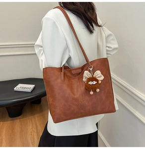 Sac fourre-tout marron vintage avec texture cuir rétro et pendentif poupée en peluche