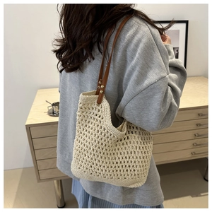 Detalle de bolso de ganchillo con diseño de malla tejida y asa de cuero al hombro