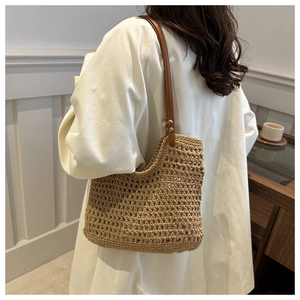 Detail of woven mesh shoulder bag with leather straps and gold rivet accents