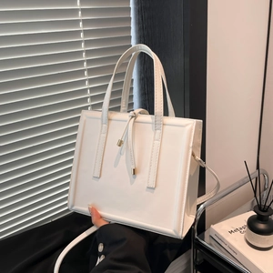 Chic white leather square handbag with dual top handles and long crossbody strap